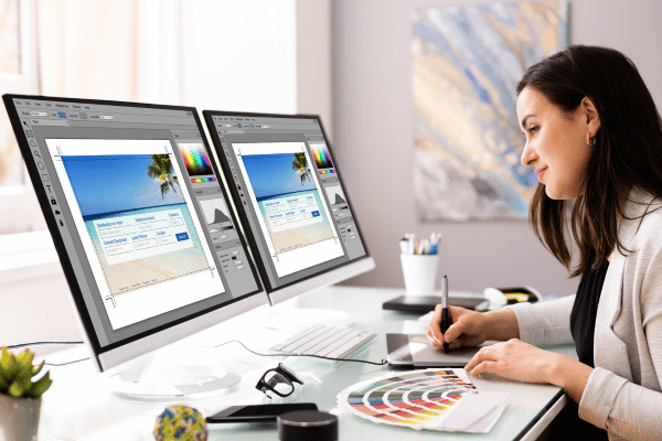 Woman sitting at a computer and designing a webpage.