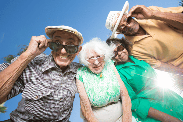 Photo of four senior citizens who are looking into the camera and smiling.