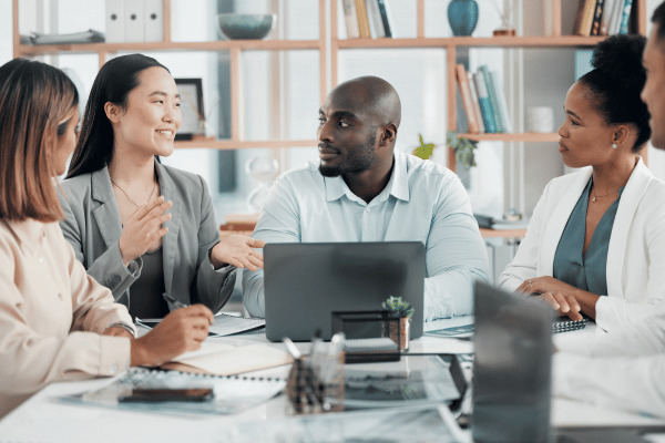 A team of marketing professionals sitting around a table during a meeting.